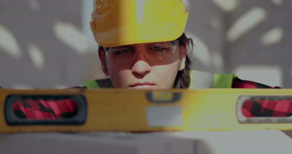 Male Construction Worker Examining Wall with Level alt