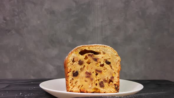 Powdered sugar poured onto Christmas Stollen fruit cake on dark background Festive pastry baking 4K alt