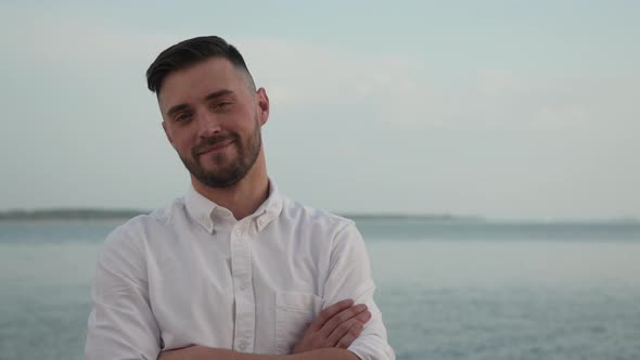 One Casual Portrait Adult Man with Crossing Hands on Sky Background  Closeup