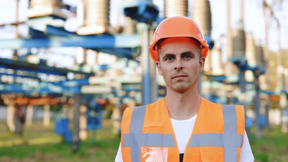 Portrait of Young Professional Heavy Industry Engineer Worker Wearing Safety Vest Putting on Hardhat