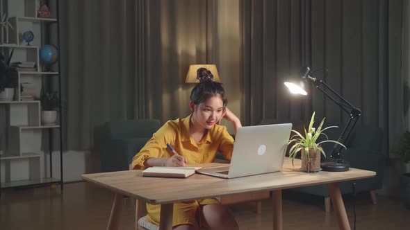 Teenage Girl Doing Homework Or Working With Laptop Computer At Home In Evening alt