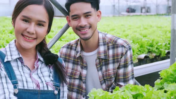 handheld asian couple farmer takecare and discuss how to growth plant in hydroponic farm alt