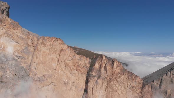 Aerial Shot of Flying Over the Mountain Peaks Among the Clouds