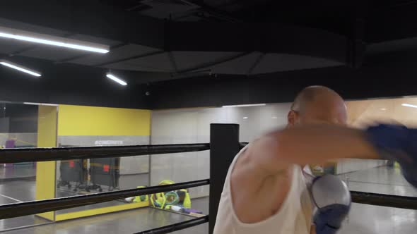 young attractive and fierce looking sport man in boxer gloves training shadow boxing workout alt