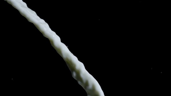 Milk Pouring Down in Slow Motion on Isolated Black Background. Healthy Drink