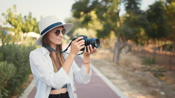 Fashion Look Pretty Cool Young Woman Model with Camera Wearing a Elegant Hat alt