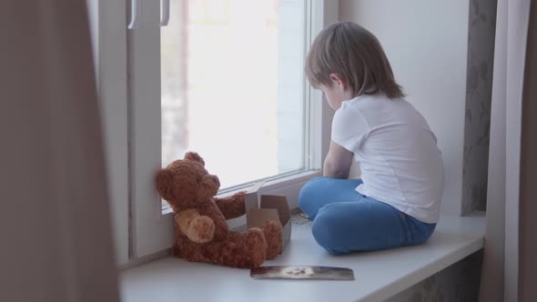 Toddler Sits on Windowsill and Plays with Scattering Pills Without Parent's Control. Dangerous alt