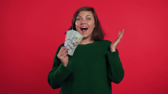 Happy Excited Girl in Green Sweater Showing money-U.S. Currency Dollars Banknote alt