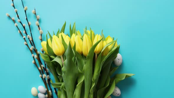 Holiday Contept Decoration with Easter Eggs and Yellow Tulips Over Blue alt