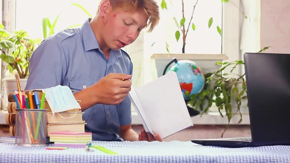 Teenager Shows Homework Through Laptop alt