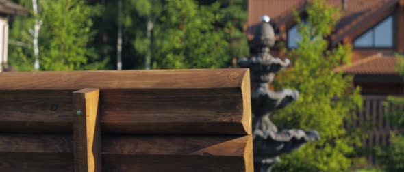 View of the House in the Cottage Village Surrounded By Trees Close Up on the Idle Fountain in the alt