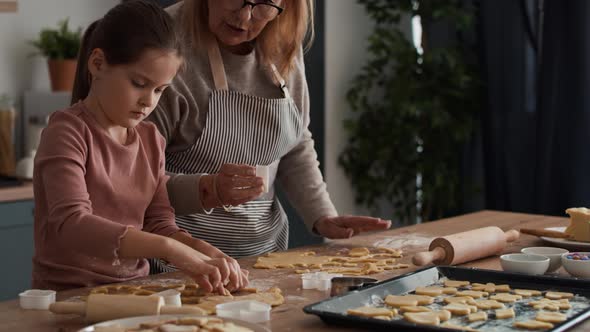 Caucasian girl baking homemade cookies with grandmother. Shot with RED helium camera in 8K alt