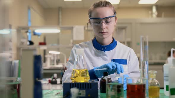 Researcher Studying Glass Flask of Chemical Spbas alt