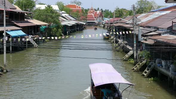 Overview from the Tha Kha Floating Market with a boat passing by alt