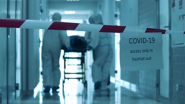 Covid-19 Concept. Hazardous Hall with Doctors Transporting a Patient Through It alt