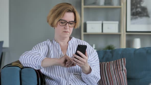 Old Senior Woman Browsing on Smartphone Using Internet alt