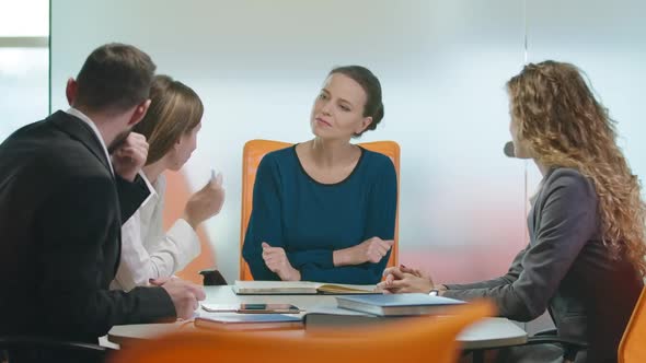Successful Beautiful Businesswoman Talking with Employees Sitting at Table in Office Indoors alt
