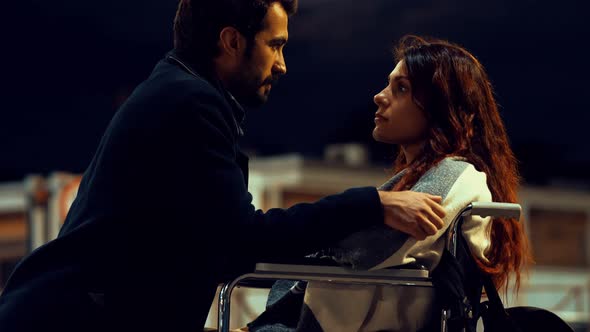 romantic kiss in the moonlight between a young man and a woman with disabilities alt