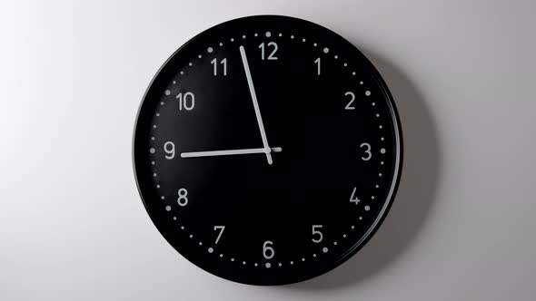 Black Clock Face in Time lapse all day on white wall