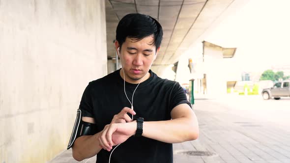 Man Using Smartwatch While Jogging alt