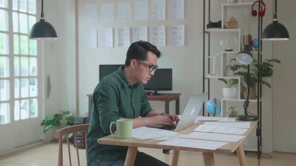 Asian Man Works With Laptop Computer And Storyboard. Video Editing, Comics Compilation alt