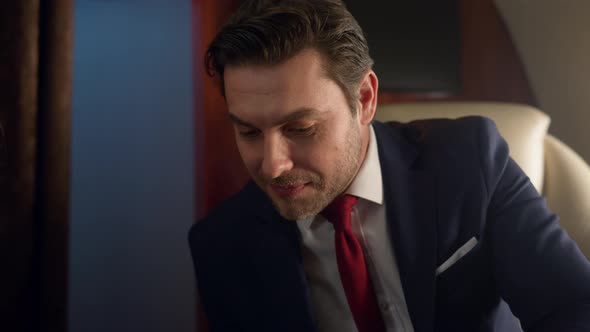 Closeup Business Couple Discuss Market Data on Tablet Computer Together on Jet alt