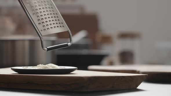 Slow Motion Orbit Shot of Gratring Vintage Cheese on Black Saucer