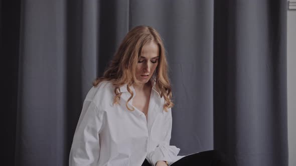Elegant Professional Model in the White Shirt Posing To a Camera in the Studio alt