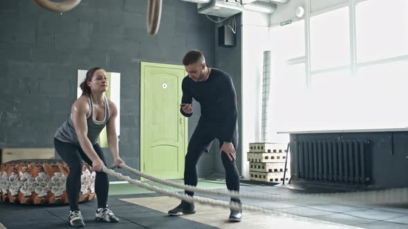 Personal Coach Controlling Woman during Rope Workout alt