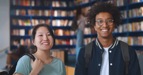 Portrait of Happy Diverse College Students Smiling at Camera in Library alt