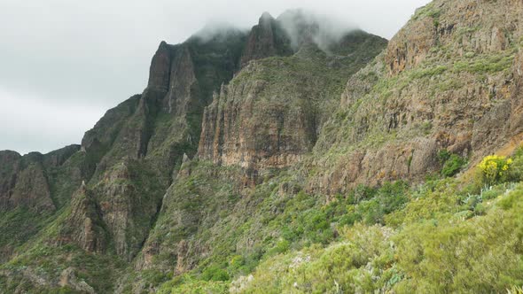 Cliffs in Masca with cloudy rolling around them, Teno, Tenerife, Spain. alt