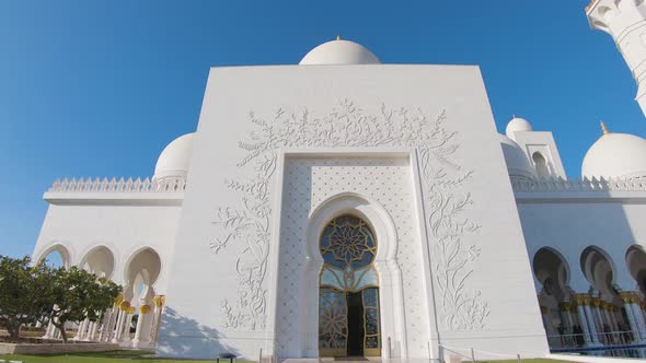 Sheikh Zayed Grand Mosque in Abu Dhabi showing its entrance gate and the beautiful gallery alt