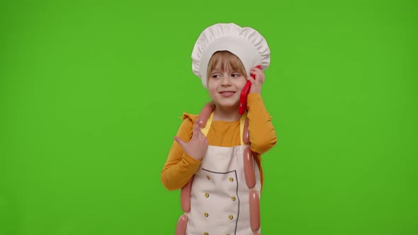 Child Girl Cook Chef Receiving Online Order Talking on Mobile Phone Making Conversation with Client alt