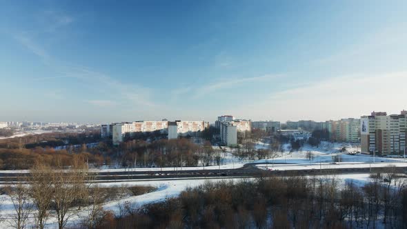 Flight over the city block. Winter cityscape. The city highway is visible. alt