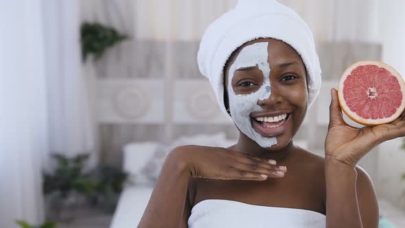 Young Afro American Woman in white Towel on Head Applied Facial Clay Mask alt
