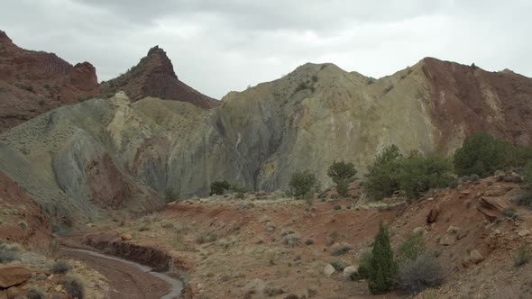 Panning shot of rock and brush layers with small creek. alt
