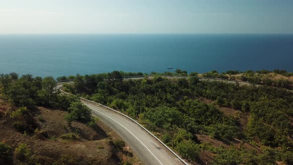 A Winding Road Through the Crimean Mountains Along the Sea alt