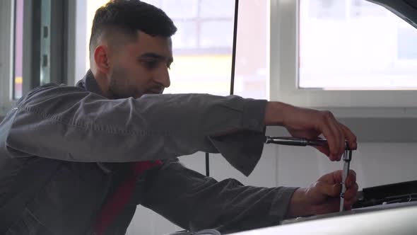 Professional Mechanic Repairing a Car in Car Repair Shop. Car Service, Repair and Maintenance alt