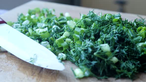 Chopped Bunch of Dill and Green Onions on Wooden Kitchen Board