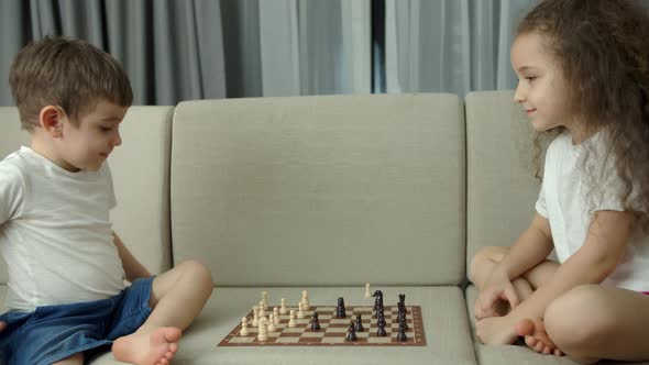 Children Play Chess While Sitting on the Devan at Home the Development of Logical Thinking in alt
