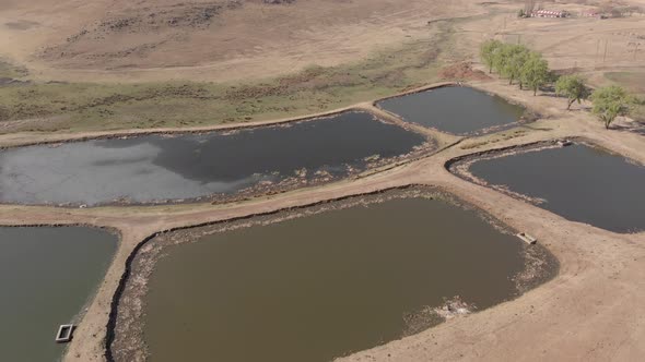 aerial circling shot of a few ponds of water alt