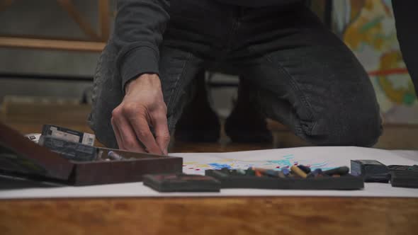 The Artist Draws a Picture with His Hands on a Large Canvas with Colored Crayons