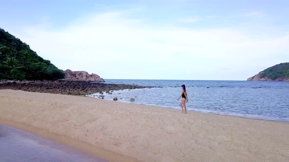 Young Pretty Woman in Black Swimsuit Walking Alone on a SandbarThailand
