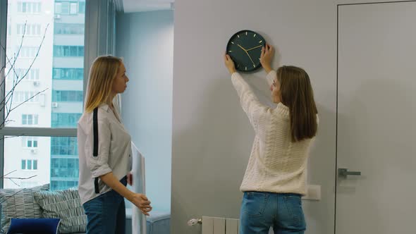 Women Designers Discussing Clocks on the Wall