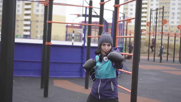 Woman in Boxing Gloves Boxing on the Street Training Ground Fight with Shadowslow Mo alt