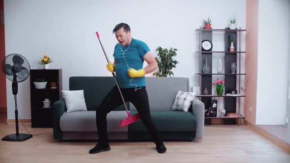 A Cleaning Man with Headphones Dances and Sings
