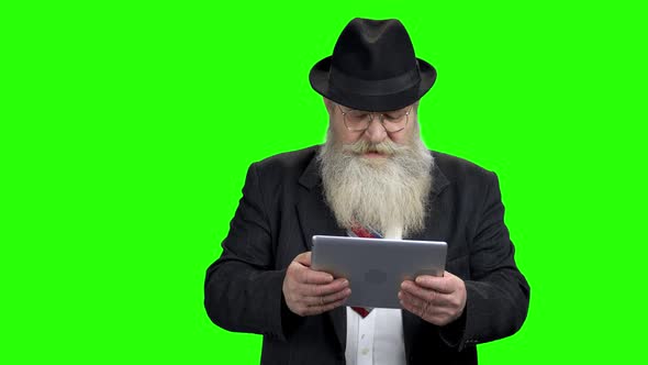 Elderly Businessman Playing Game on Tablet Pc alt