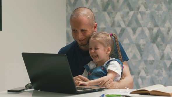 Happy Daughter with Father Have Fun Playing on Modern Laptop alt