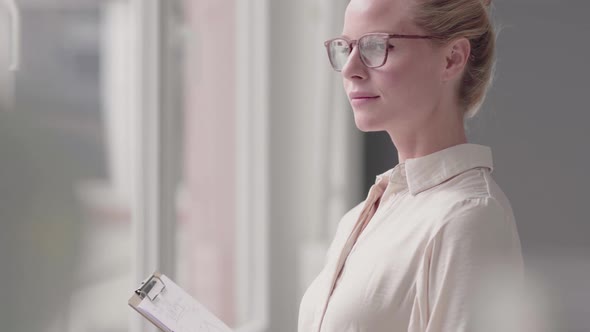 Smiling businesswoman with clipboard in office