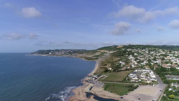 Aerial tracking forward towards the quaint village of Charmouth in the heart of the Dorset countrysi alt